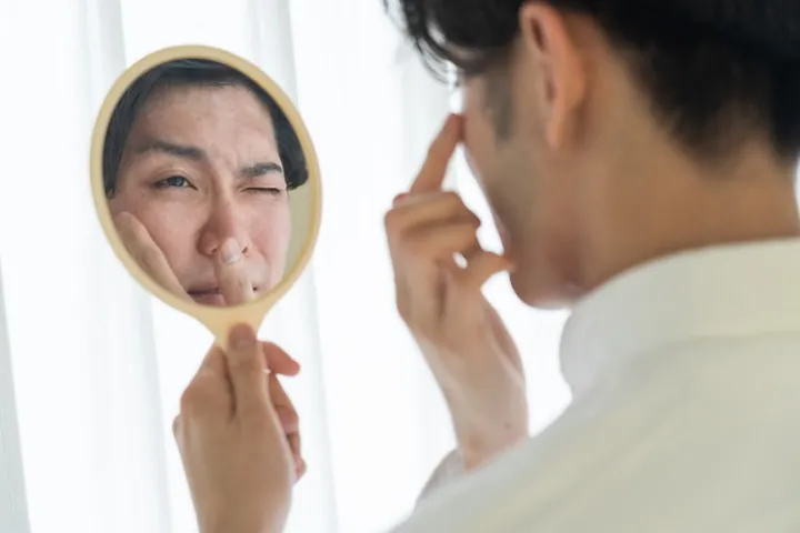自分で整えた眉を鏡で見て困る男性