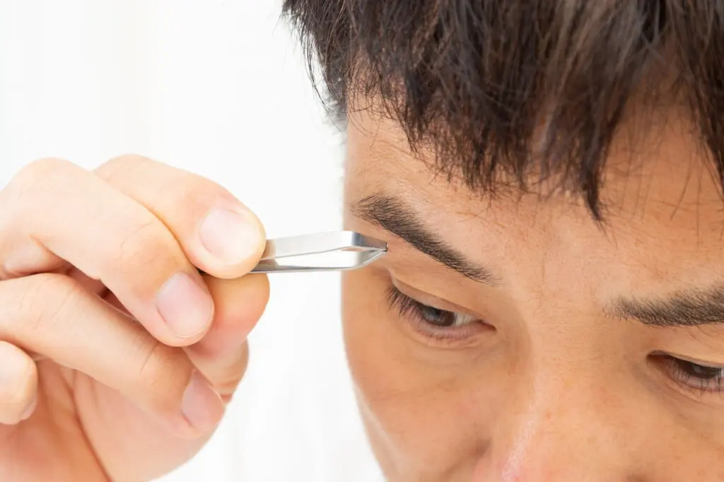 眉毛を抜く男性